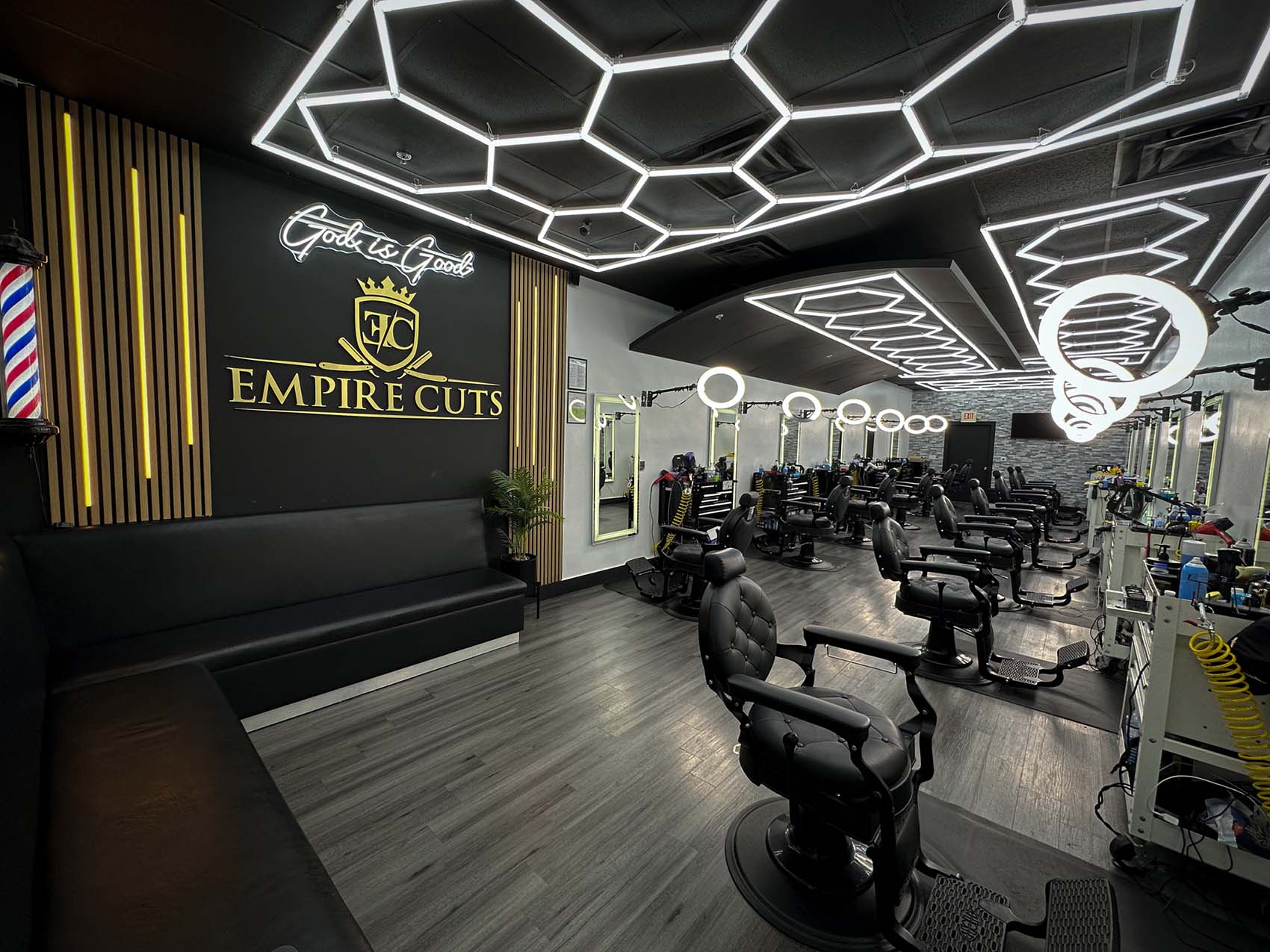 The real Empire Cuts interior, with the logo wall, glass frontage, and rows of barber chairs