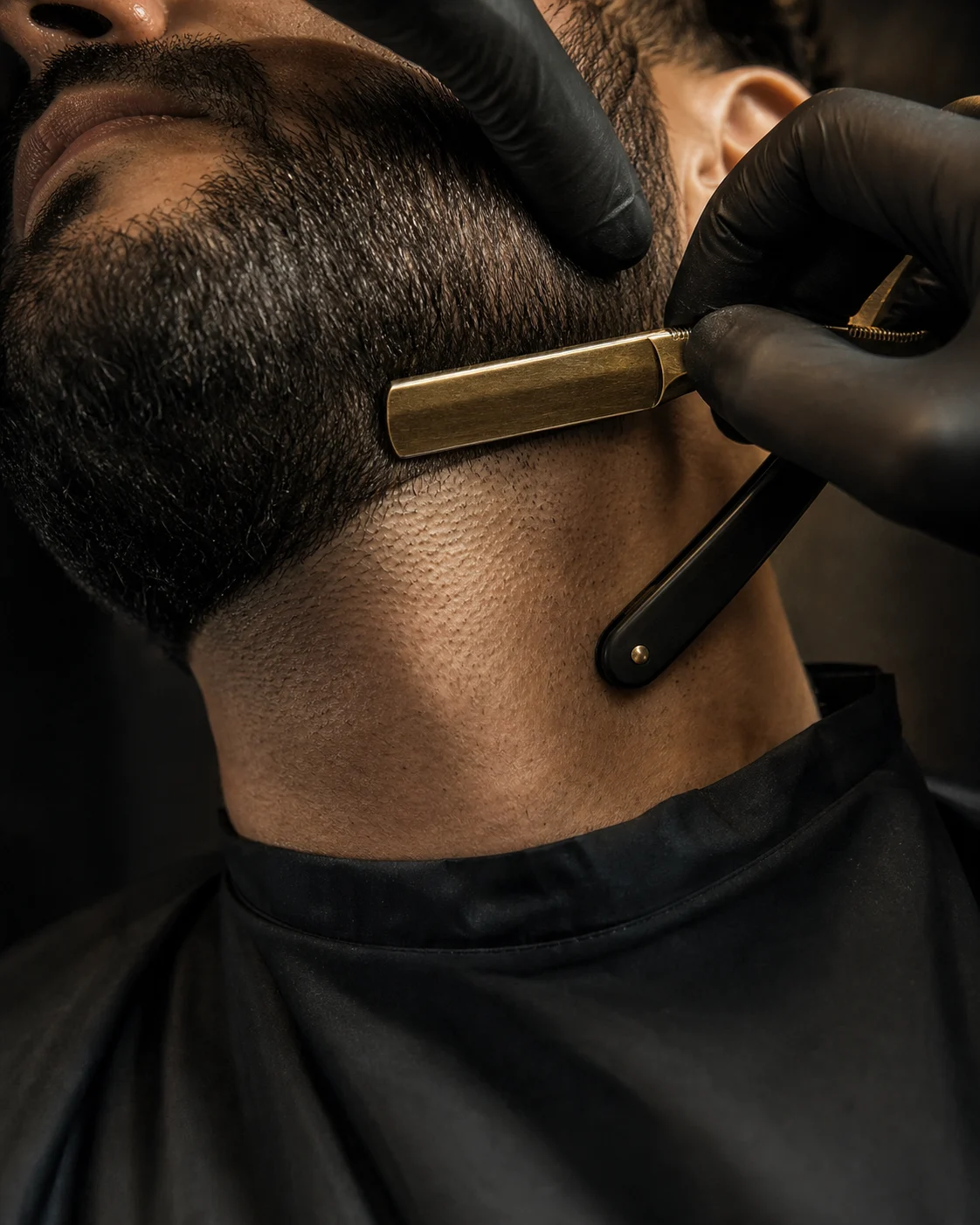Barber defining a crisp beard line with careful detail work
